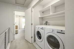 Dedicated laundry area featuring stacked appliances and open shelving