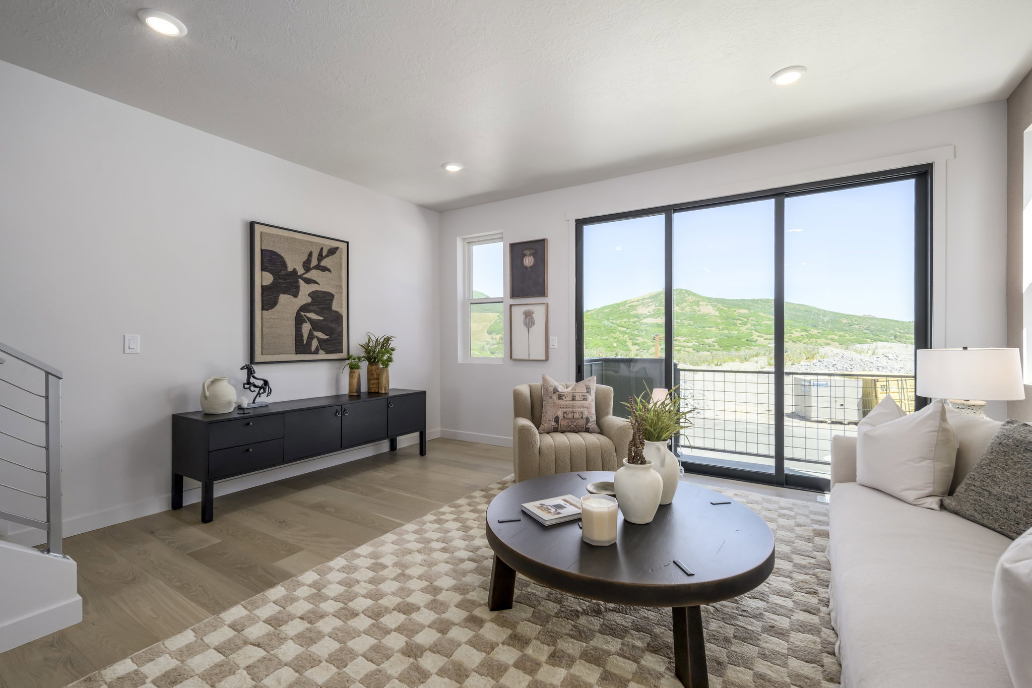 Light wood-finish flooring complements the white walls of this living space