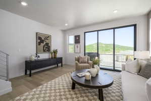 Light wood-finish flooring complements the white walls of this living space