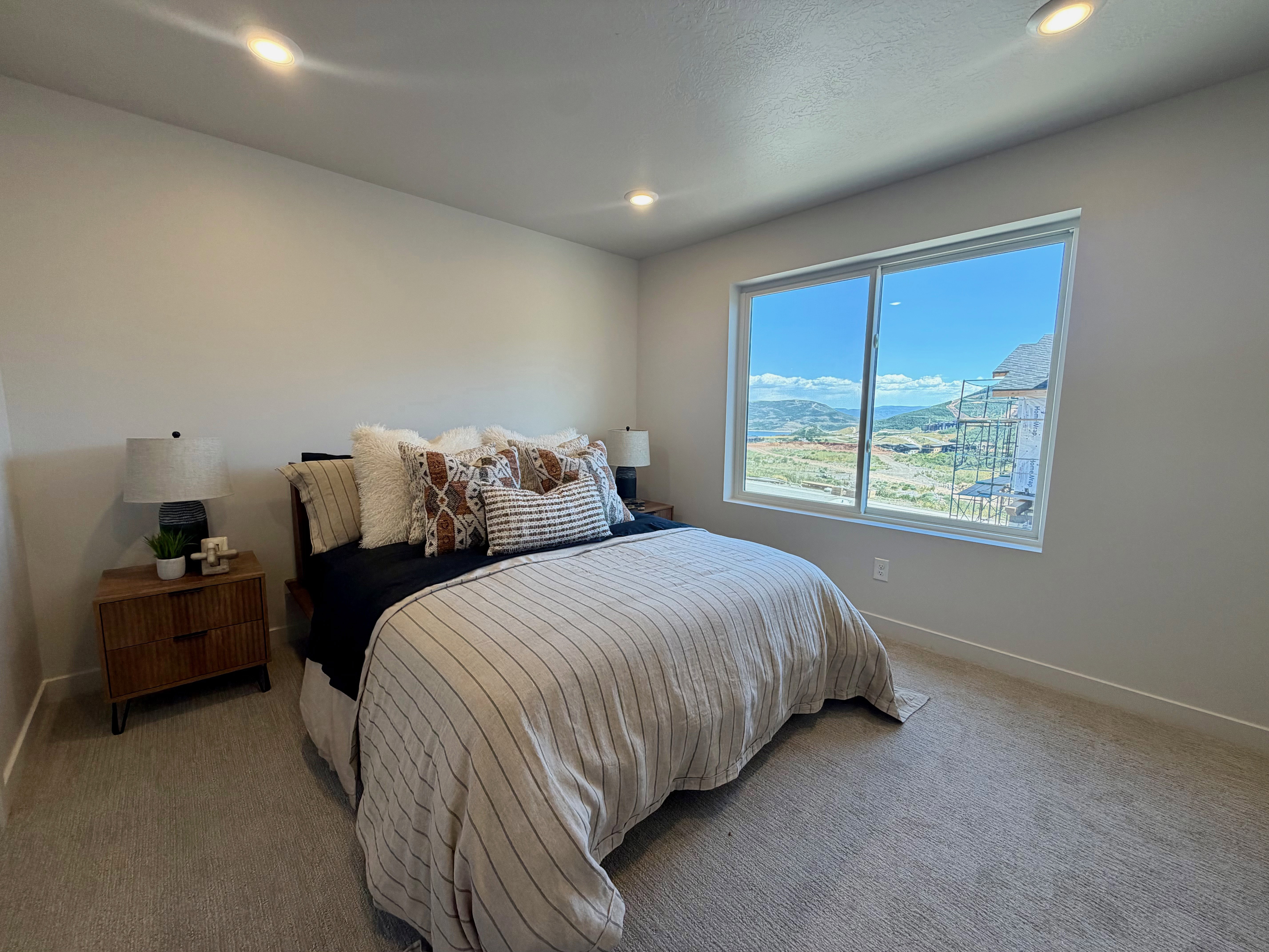 Bedroom with a large window and distant landscape scenery
