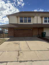 View of front of house with driveway, an attached garage, and brick siding