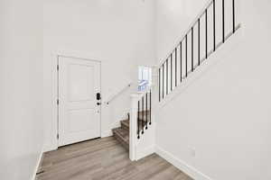 Foyer entrance with light wood-style floors and a high ceiling