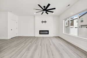 Unfurnished living room with light wood-style floors, a fireplace, a ceiling fan, and recessed lighting
