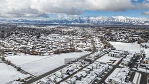 Snowy aerial view featuring a residential view and a mountain view