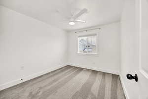 Unfurnished room with light colored carpet and ceiling fan