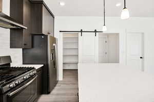 Kitchen with gas stove, a barn door, and dark wood finish cabinetry
