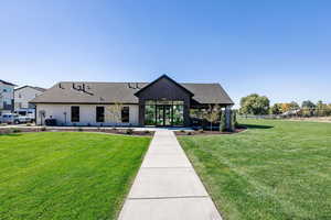 View of front of property featuring a shingled roof, a front lawn, and board and batten siding