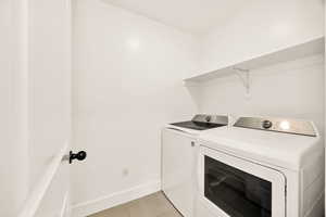 Laundry area with separate washer and dryer and light tile patterned floors