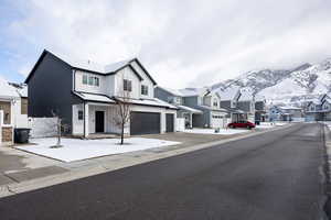 View of front of property with a residential view, a garage, driveway, and a mountain view
