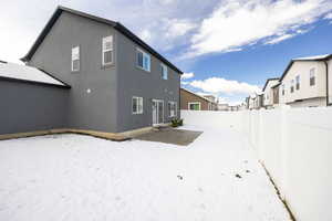 Rear view of house featuring a fenced backyard, stucco siding, a residential view, and a patio