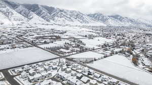 Snowy aerial view featuring a mountain view and a residential view