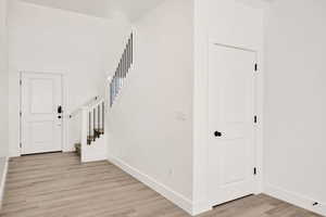 Foyer entrance with stairway and light wood-style flooring