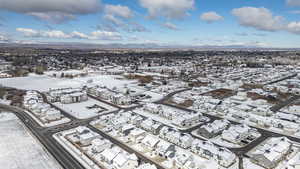 Snowy aerial view featuring a mountain view and a residential view