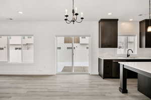 Unfurnished dining area featuring a chandelier and light wood finished floors