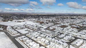 Snowy aerial view with a mountain view and a residential view