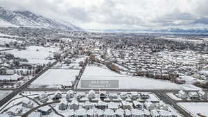 Snowy aerial view featuring a residential view and a mountain view