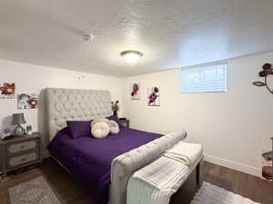 Bedroom with a textured ceiling and dark wood-style floors