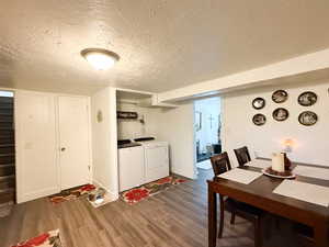 Dining room featuring a textured ceiling, wood finished floors, and washing machine and dryer