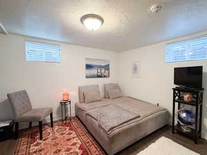 Bedroom with a textured ceiling and wood finished floors