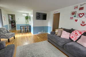 Living area featuring light wood-type flooring and a chandelier