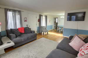 Living room featuring light wood finished floors and a chandelier