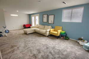 Carpeted living area featuring french doors