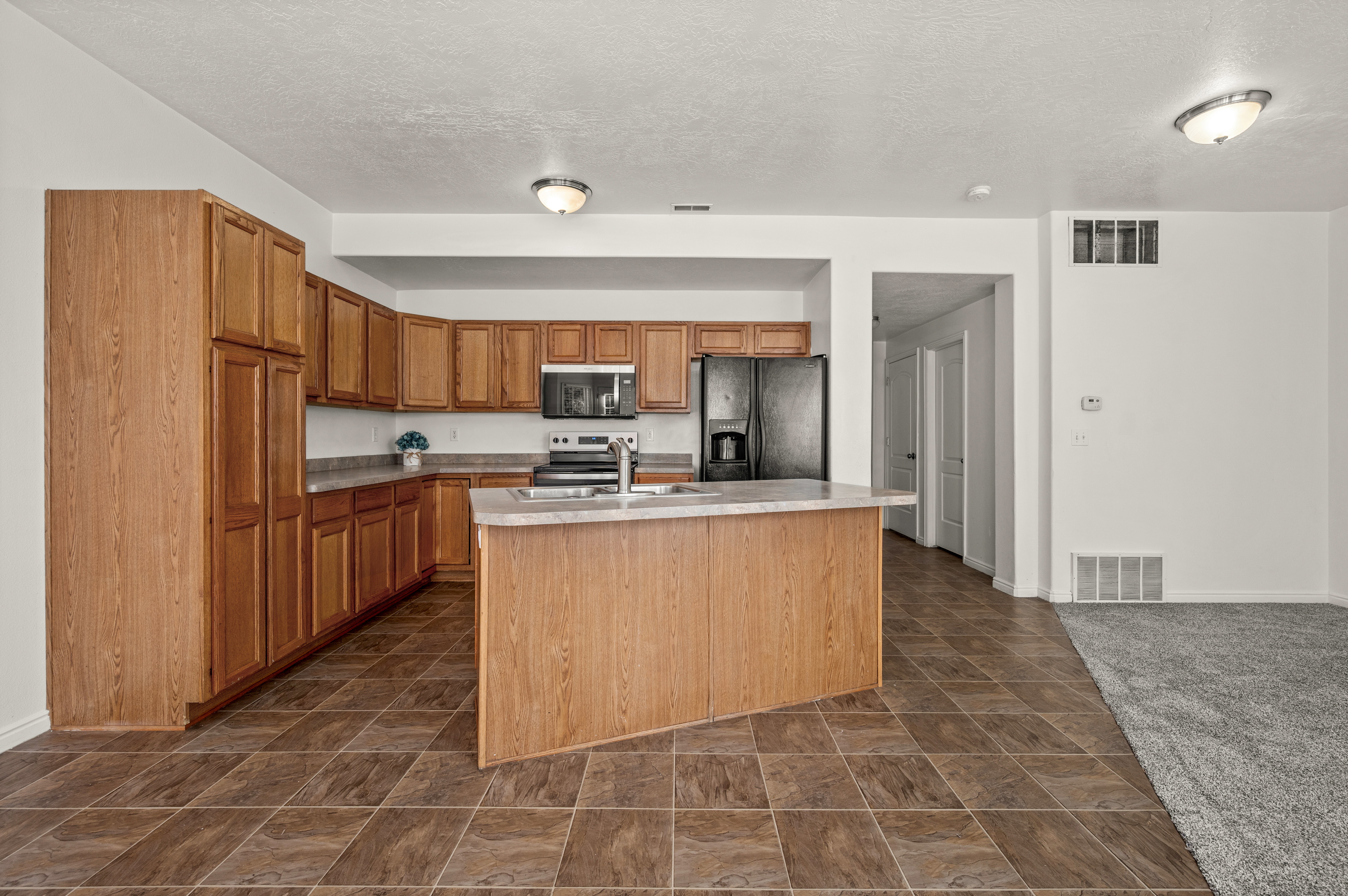 Open concept kitchen, featuring new oven, microwave, dishwasher.