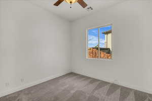 Carpeted spare room featuring baseboards and ceiling fan