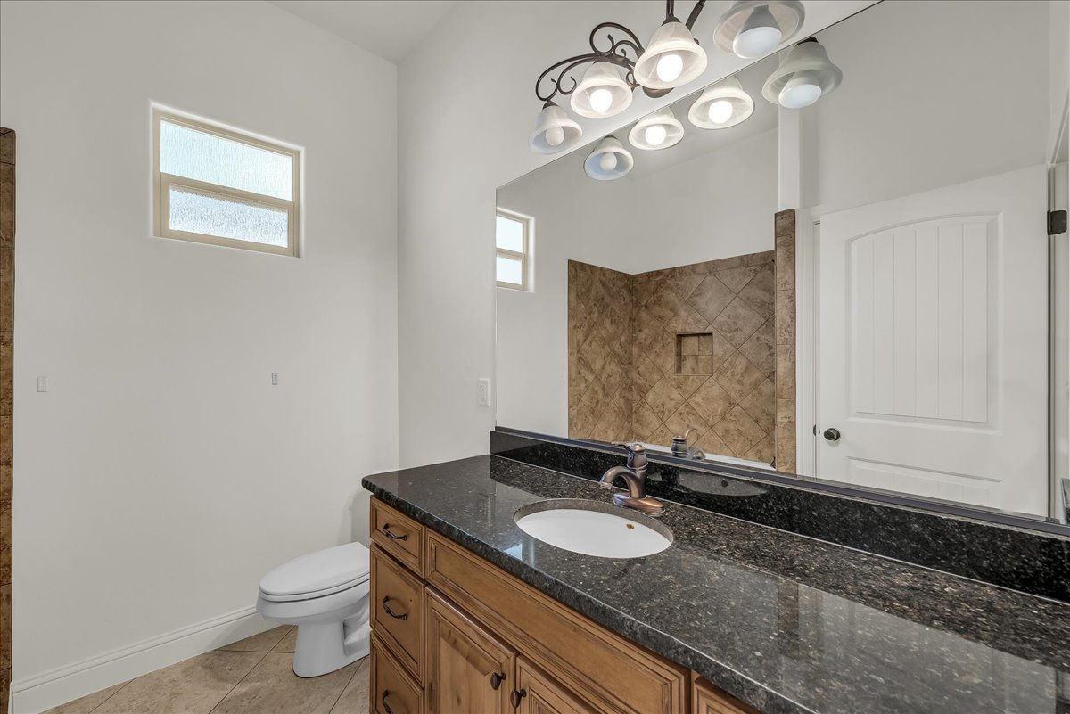 Bathroom featuring vanity, light tile patterned flooring, and tiled shower