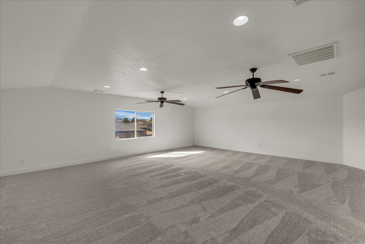Unfurnished room featuring carpet, recessed lighting, a ceiling fan, and lofted ceiling