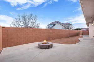 Fenced backyard featuring a patio area and an outdoor fire pit