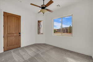 Unfurnished room with light colored carpet and a ceiling fan