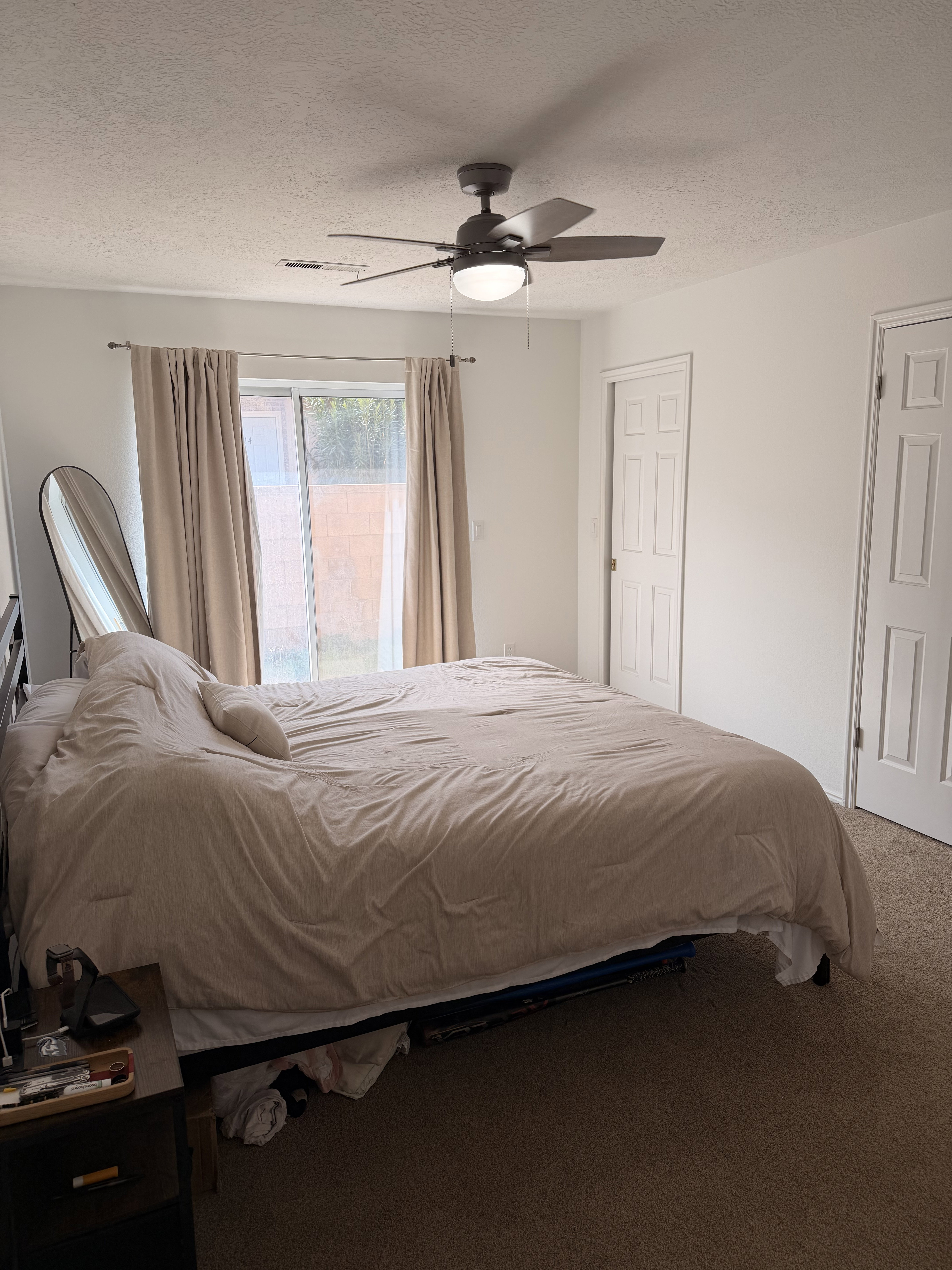 Carpeted bedroom featuring a textured ceiling and ceiling fan