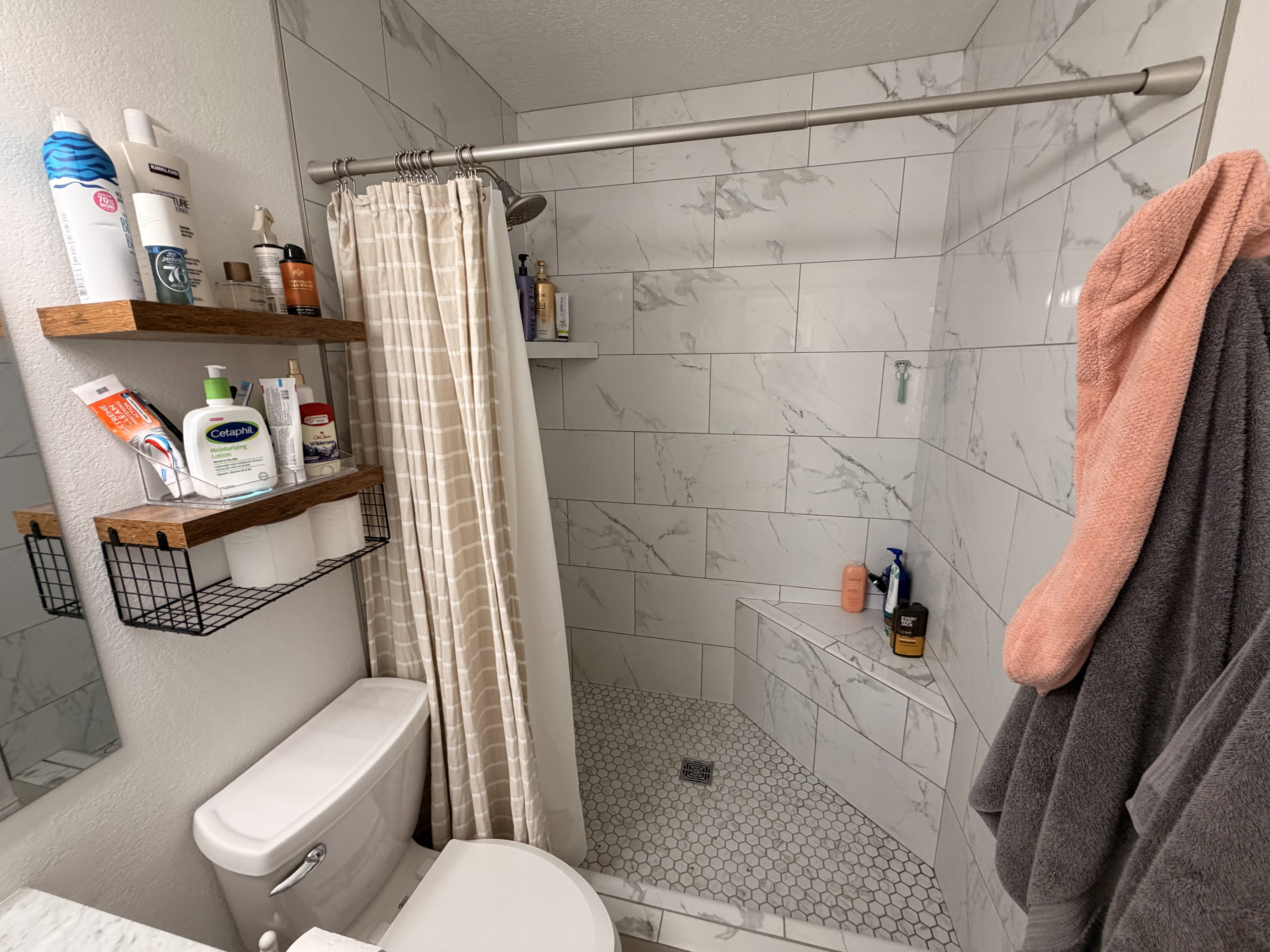 Full bathroom with a textured wall, a shower stall, and a textured ceiling