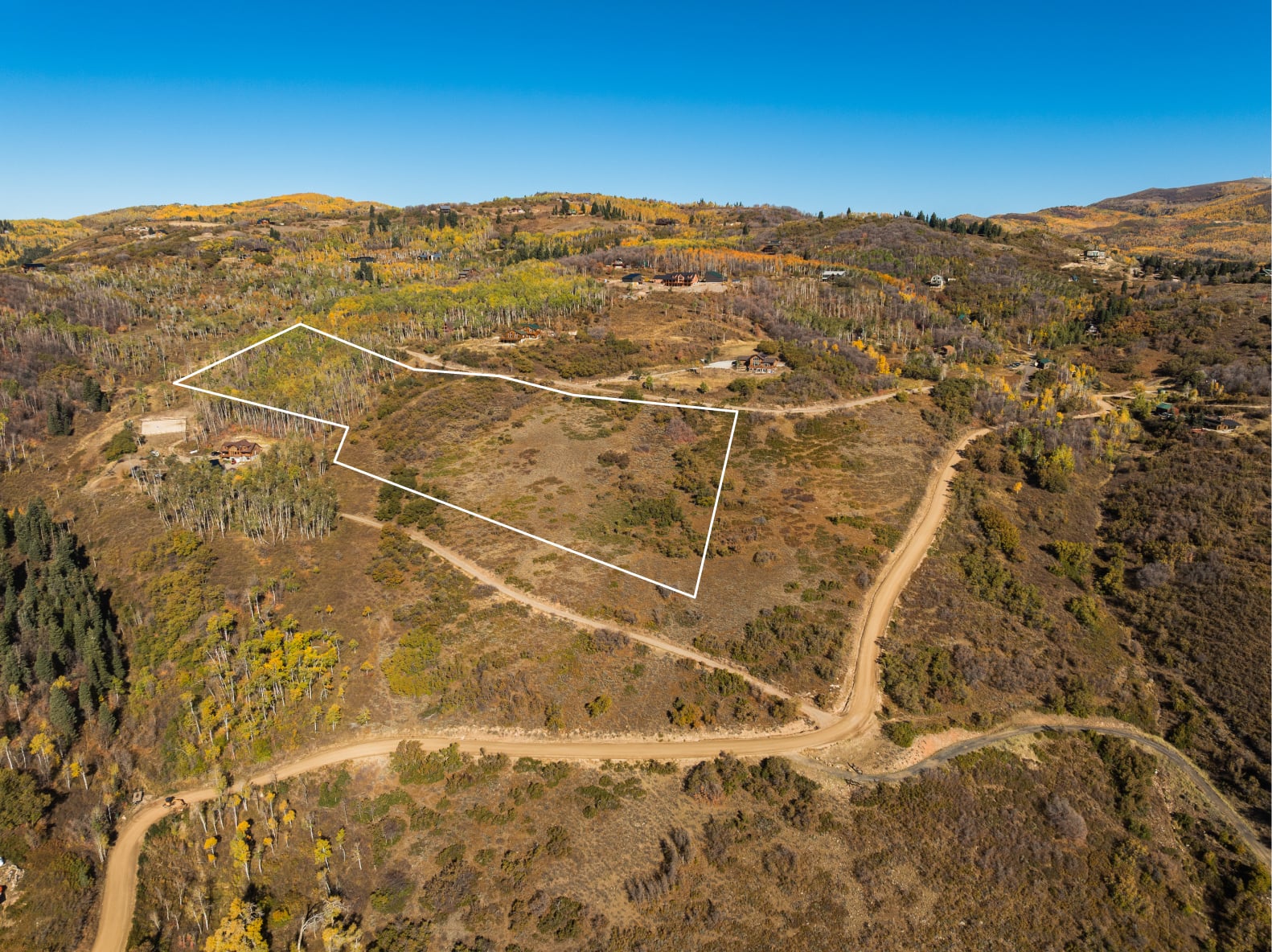 Aerial view of property's location with property boundaries highlighted and a mountain backdrop