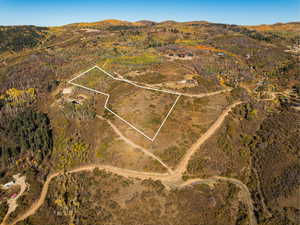 Aerial overview of property's location featuring property boundaries highlighted and a mountainous background
