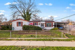 View of front of home with a carport and a fenced front yard