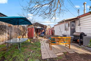 Fenced backyard featuring a storage unit and a patio area