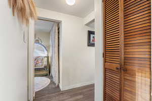 Hall featuring dark wood-type flooring and baseboards