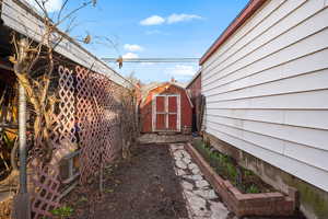 View of property exterior featuring a storage shed