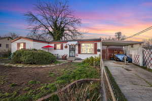 View of front of property featuring a carport and concrete driveway