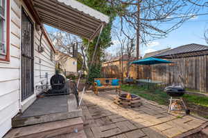 Fenced backyard with an outdoor fire pit, a patio, and a grill