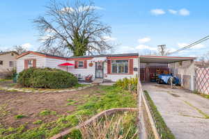 View of front facade with an attached carport and concrete driveway