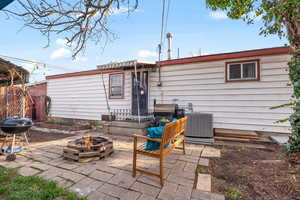 Rear view of house featuring an outdoor fire pit and a patio