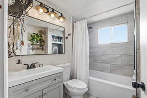 Bathroom featuring vanity and shower / bath combination with curtain