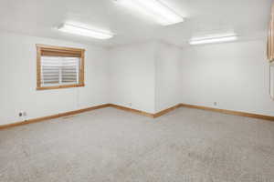 Unfurnished room with light colored carpet and a textured ceiling