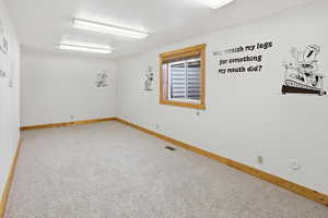 Unfurnished room with light carpet and baseboards
