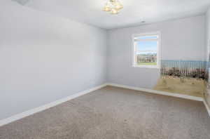 Carpeted empty room featuring baseboards