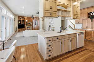 Kitchen with open floor plan, open shelves, light wood-style floors, light countertops, and light wood finish cabinetry