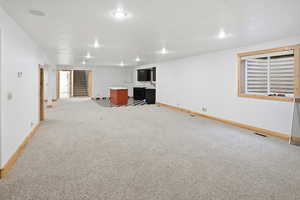 Finished basement featuring stairway and light colored carpet